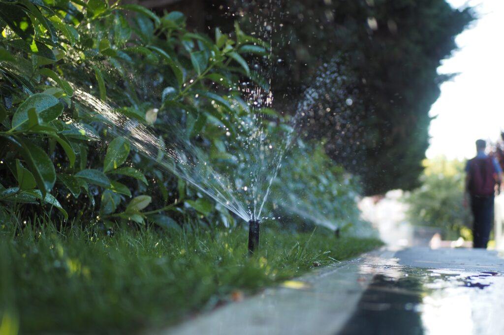 automatic watering grass, garden lawn sprinkler in action.