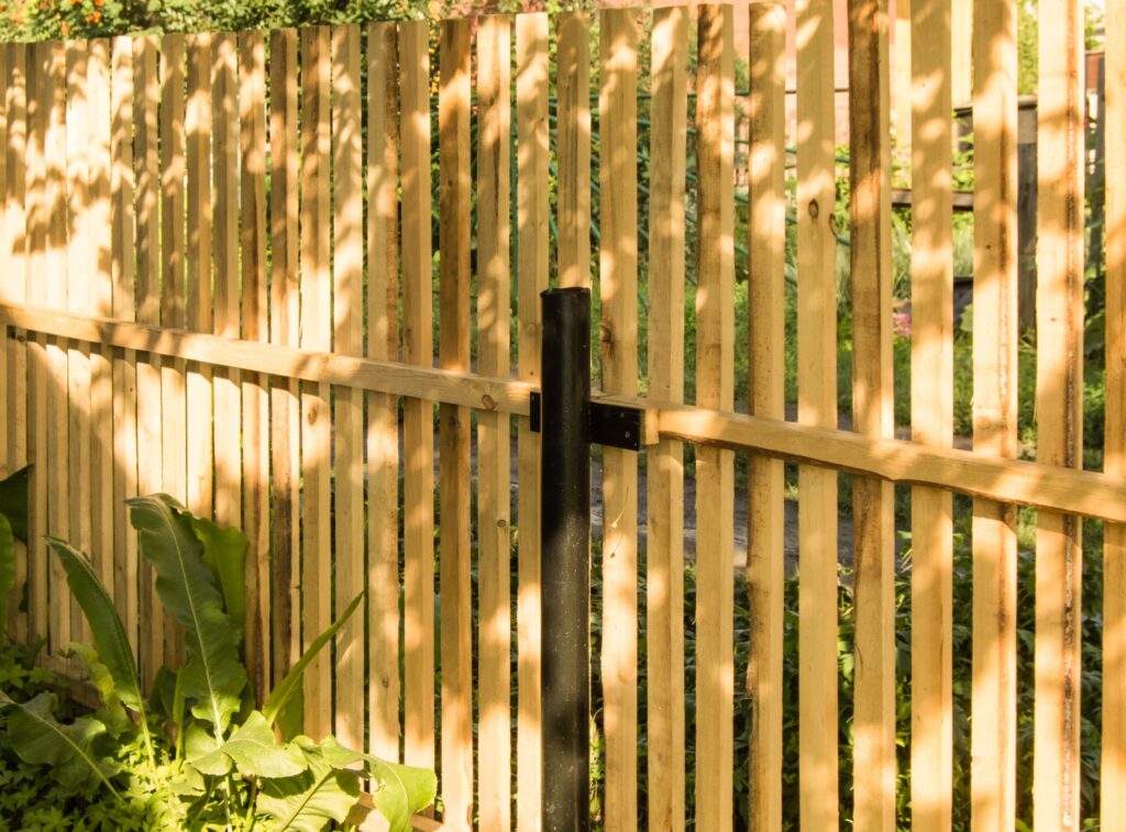 New picket fence and black metal poles, built in the garden